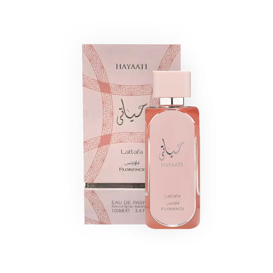 Parfum Hayaati Florence 100ml - Lattafa. Flacon élégant rose poudré avec un design épuré et bouchon assorti, accompagné d'une boîte rose ornée de motifs géométriques subtils. Eau de parfum pour femme, offrant des notes florales et fruitées délicates. Parfait pour une fragrance douce, féminine et sophistiquée.